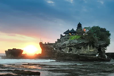 A sea temple silhouetted at sunset