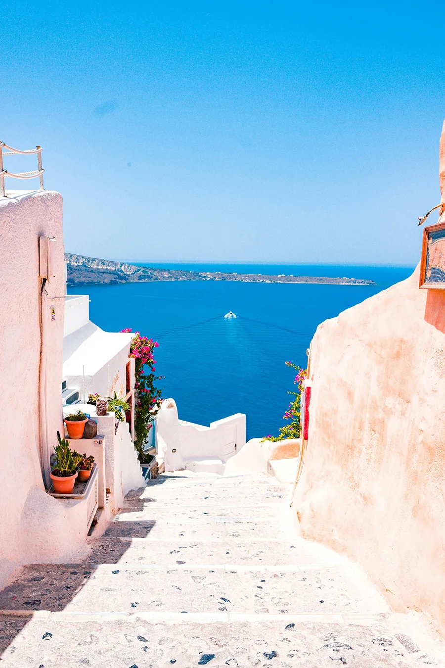 A whitewashed stepped alley opening onto deep blue sea