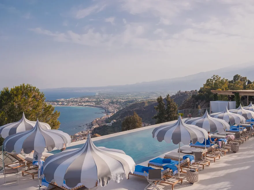A cliff-edge pool above the bay at Taormina, with the coast beyond