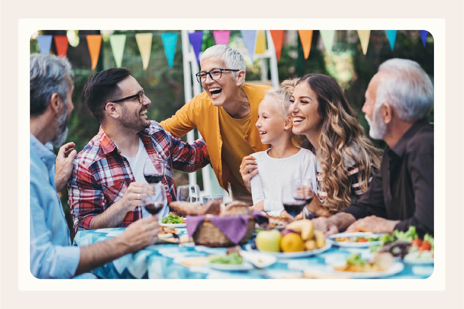 Colorful party table surrounded by three generations of a family celebrating