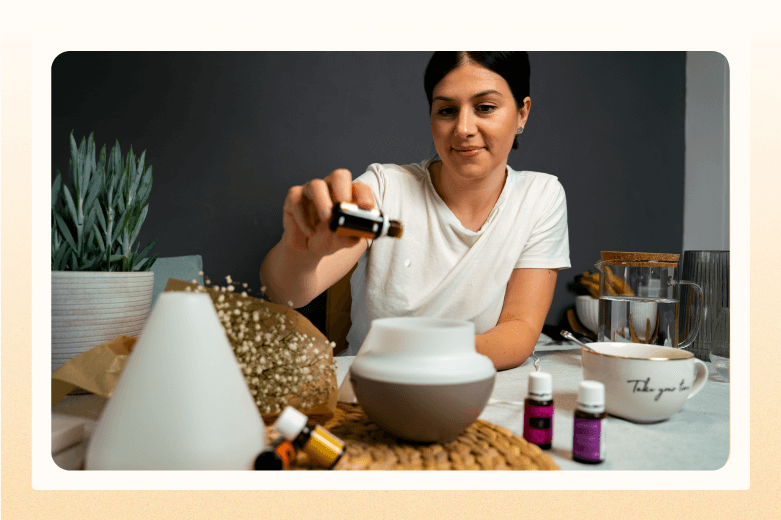 woman dripping oil from small bottle into diffuser