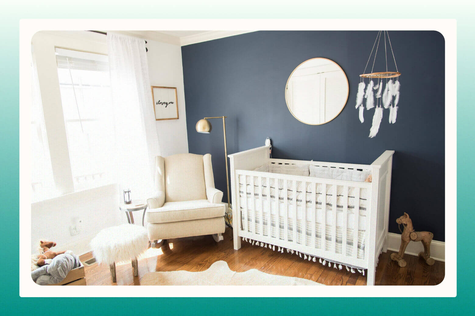 Baby's nursery decorated in mostly white with one dark dramatic wall painted black