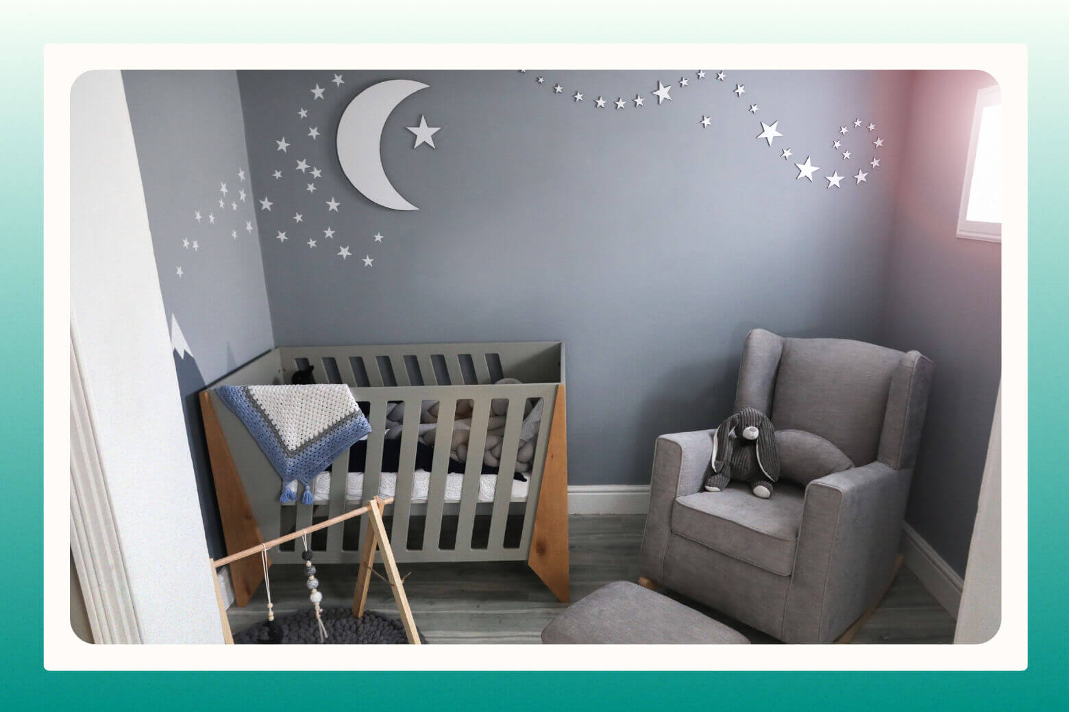 Baby's gender neutral nursery with a crescent moon and stars on gray walls