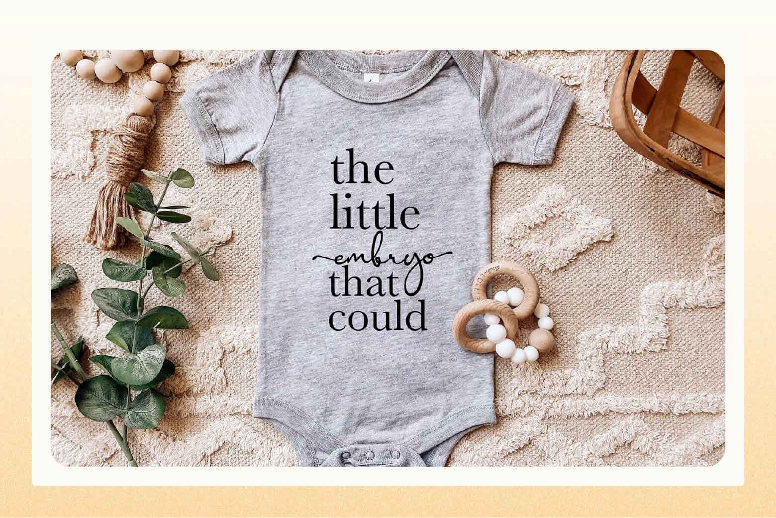 Grey onesie that says "the little embryo that could"
