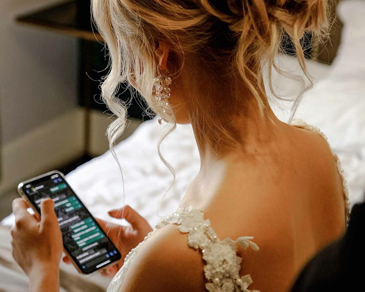 A bride holding a phone on her wedding day