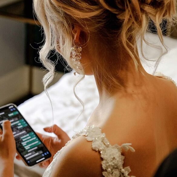A bride holding a phone on her wedding day
