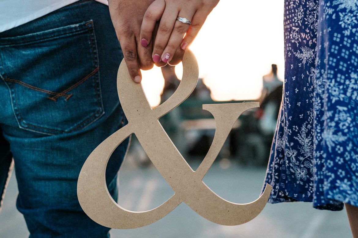 Creative engagement announcement idea with two hands holding an ampersand sign