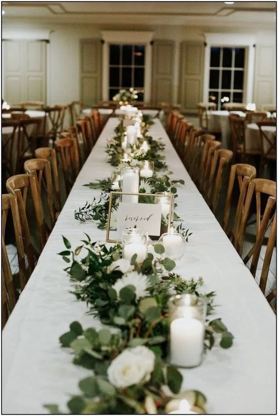 garlands of greenery centerpiece arranged on a wedding reception table 