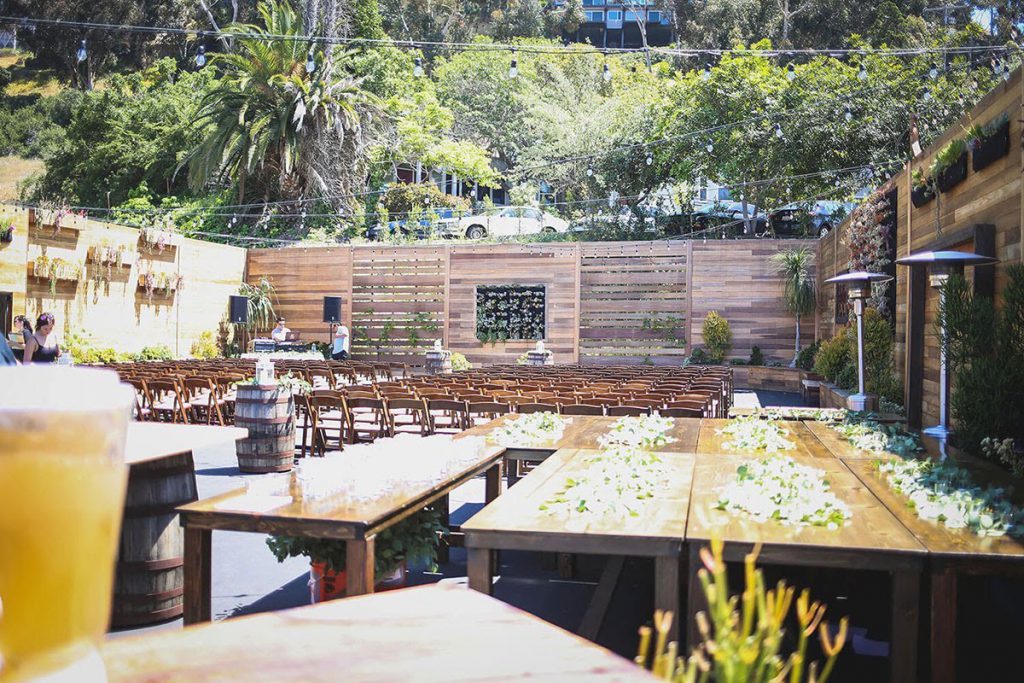 outdoor wedding reception setup at lot 8 in san diego surrounded by wood and greenery