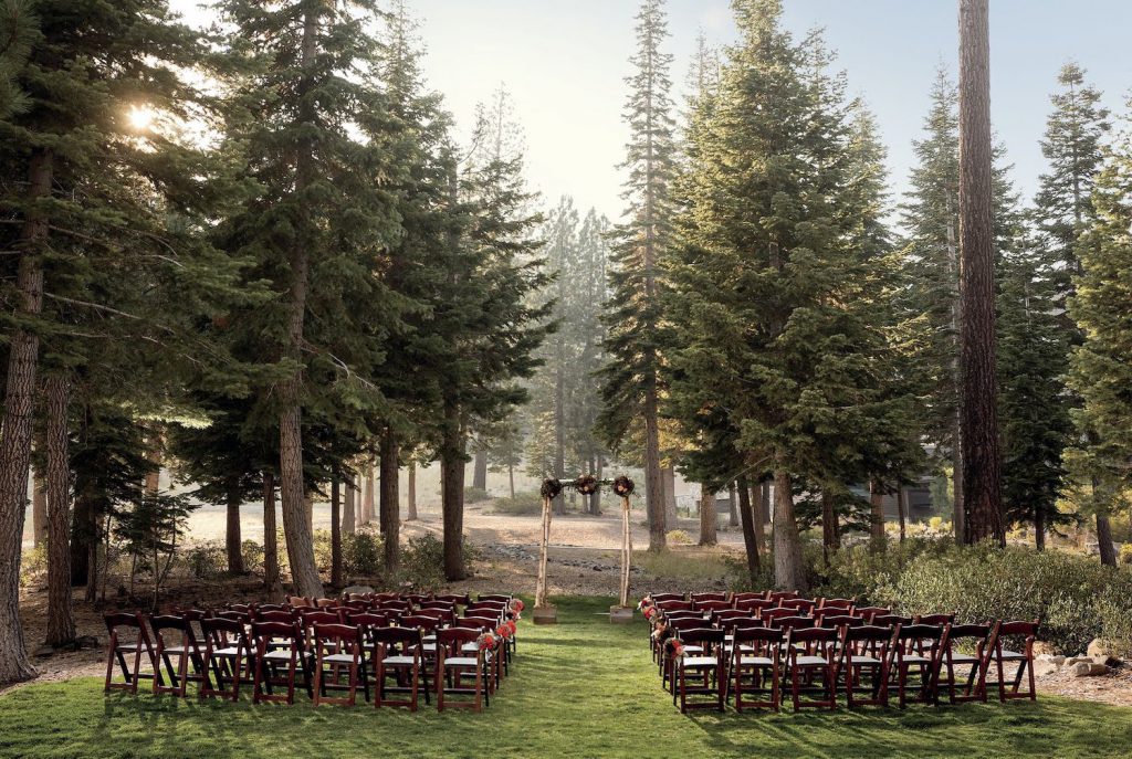 chairs and an arch for a wedding ceremony at the ritz carlton lake tahoe, set up slope-side amongst the pine trees