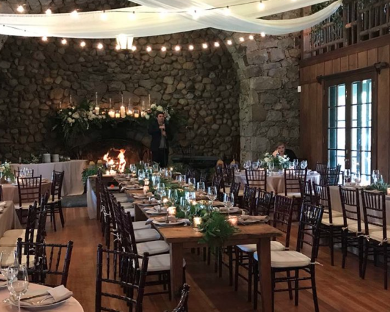 the grand hall at valhalla at lake tahoe set with tables, chairs, place settings, and centerpieces for a wedding reception