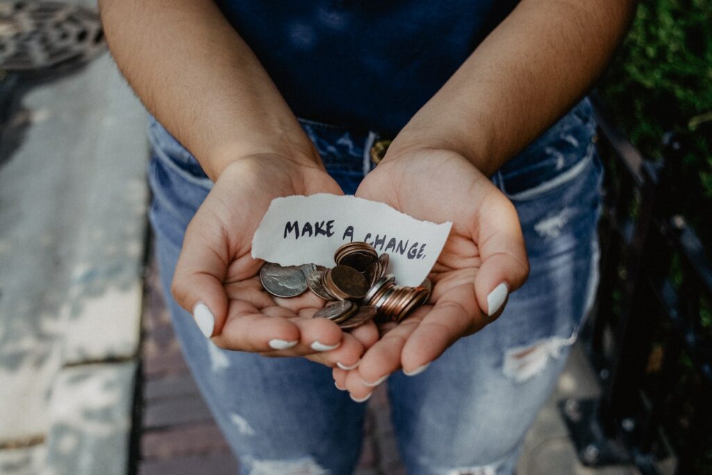 hands holding change with note that says 'make a change'