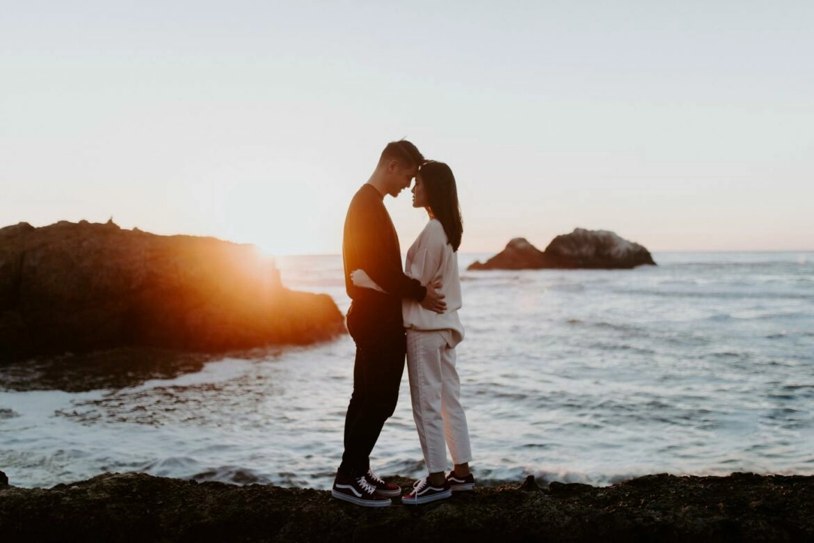 A couple looking into one another’s eyes during an engagement photo shoot at Sutro Baths.