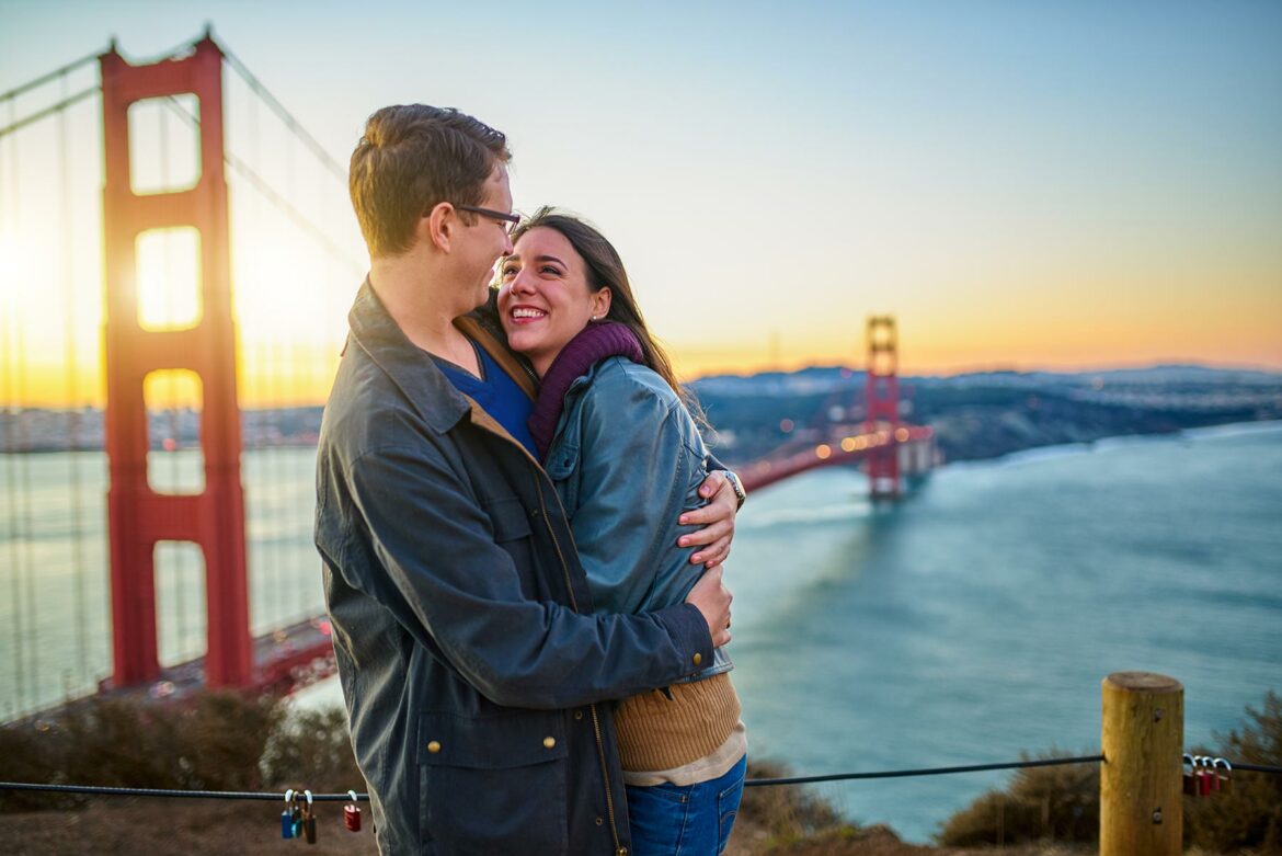 Couple embracing for their San Francisco engagement photo in front of the Golden Gate Bridge