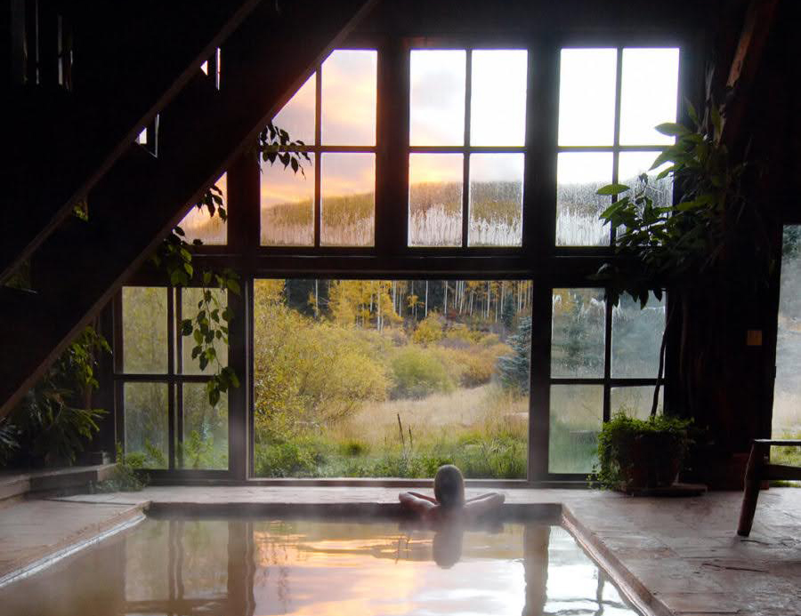 A person soaking in the Dunton Hot Springs while looking out at the mountains