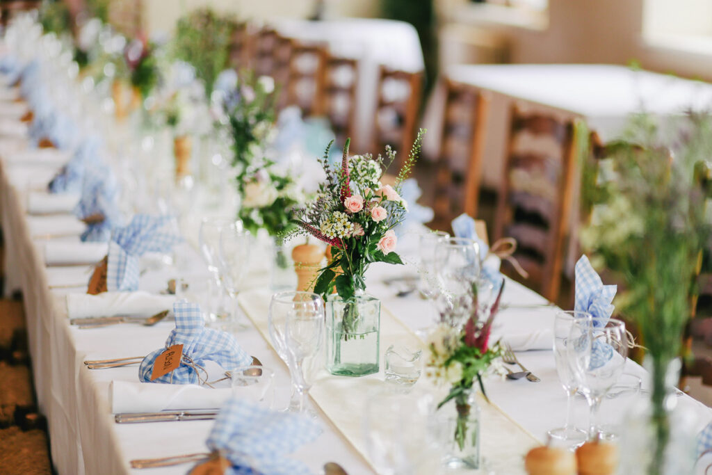 Simple flower centerpieces on a community table in clear vases