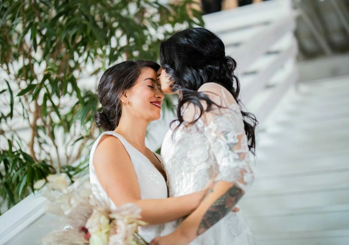 Two newlywed women embracing on their wedding day