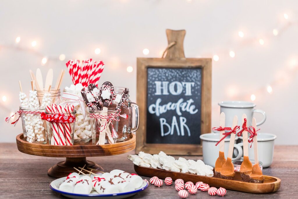 a hot chocolate station with peppermint balls, straws and chocolate spoons