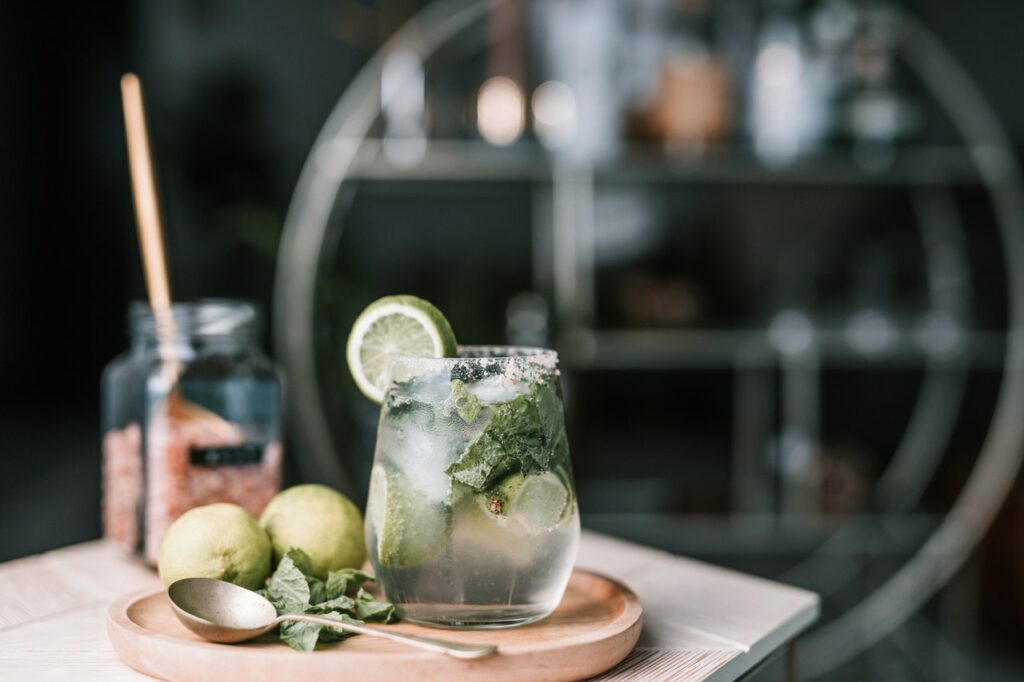 Nojito mocktail next to a spoon, mint and limes