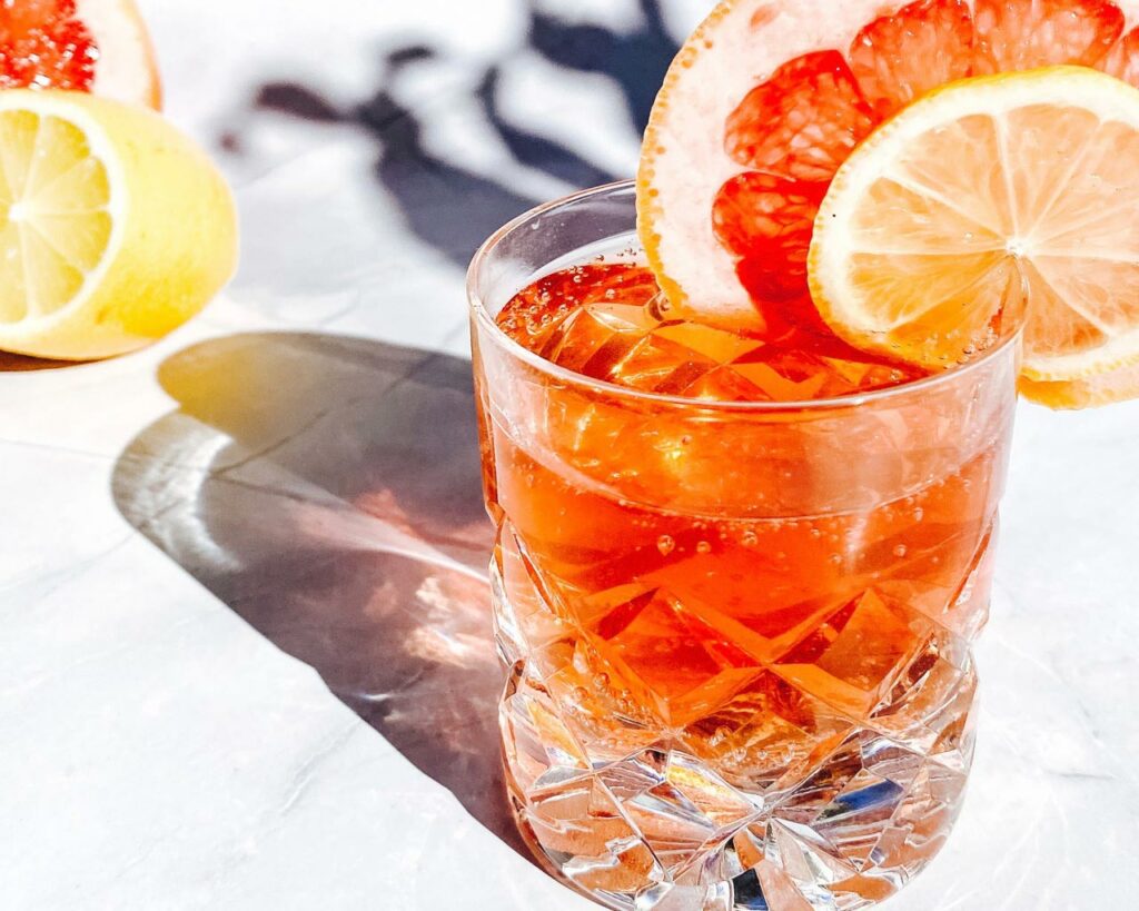  punch in crystal glass with grapefruit and lemon garnish