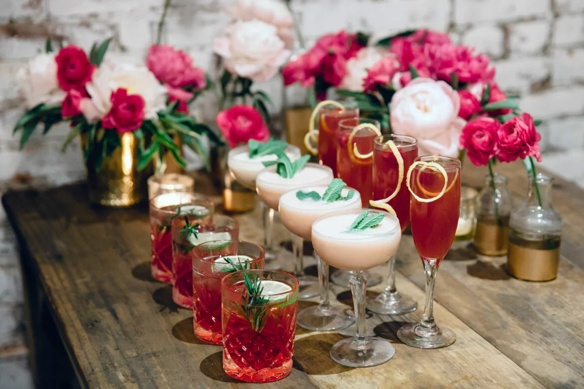 Three types of wedding cocktails in front of flower arrangements