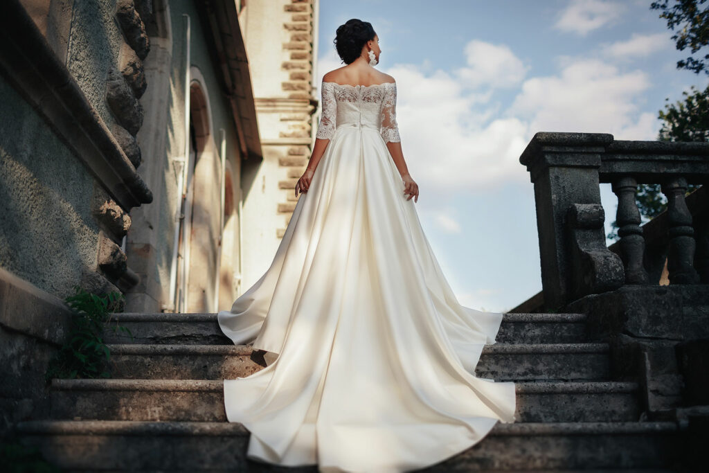 Woman in a wedding dress walking up a flight of outdoor stairs