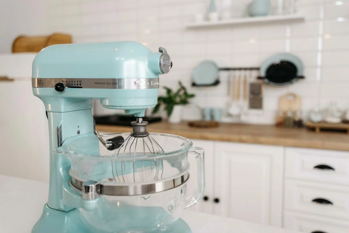 Tilt-head stand mixer on kitchen counter with glass mixing bowl