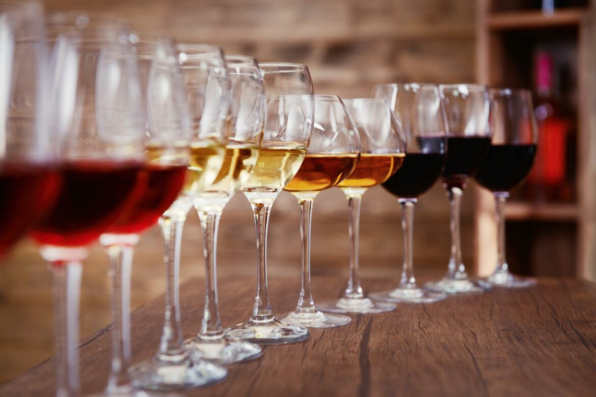 A row of half-filled wine glasses on a table