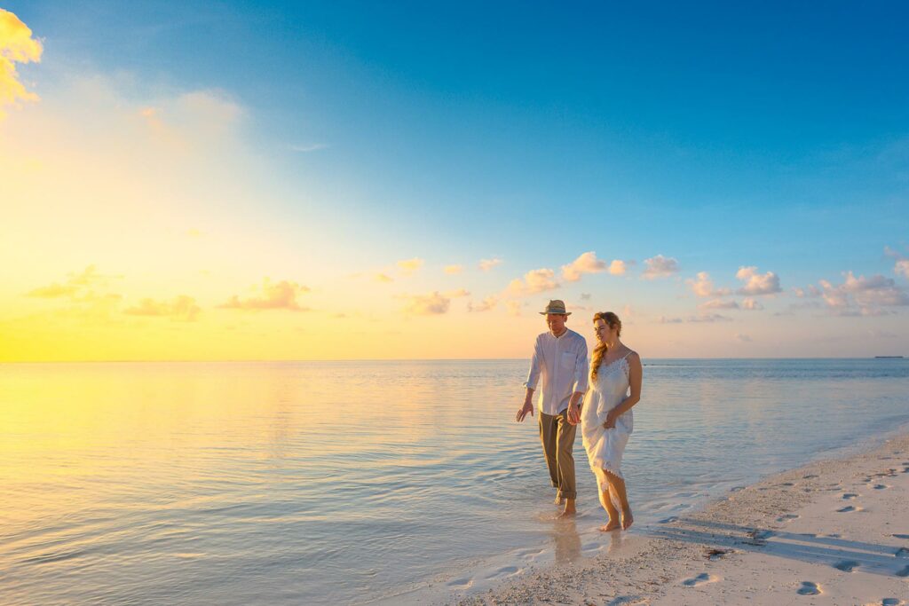 A couple walking on the beach during their honeymoon