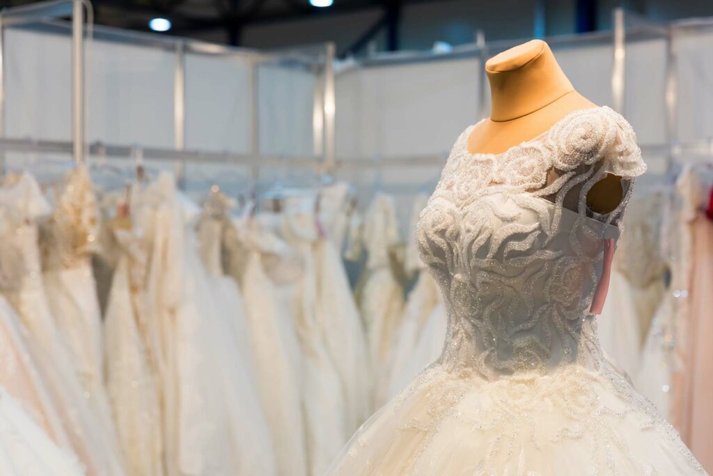 Wedding dress on a dress form featuring a high neckline with lace