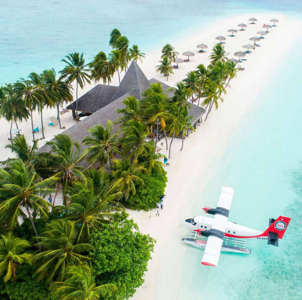 A seaplane parked in the water next to the Veligandu Island Resort and Spa on Veligandu Island in the Maldives