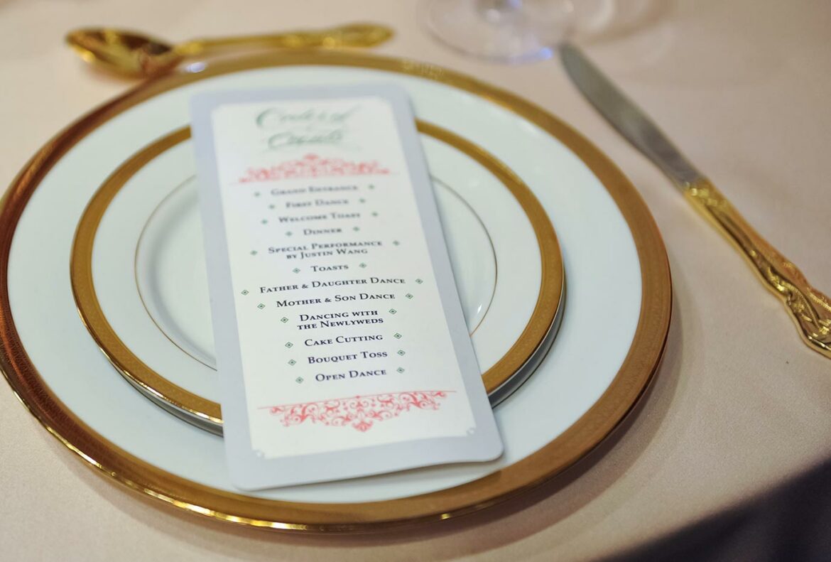 A wedding program on a reception table place setting