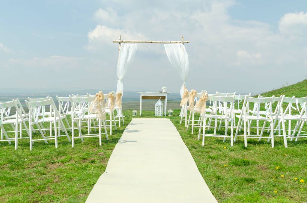 A small bluff-top wedding ceremony venue with an aisle runner, chairs and a table
