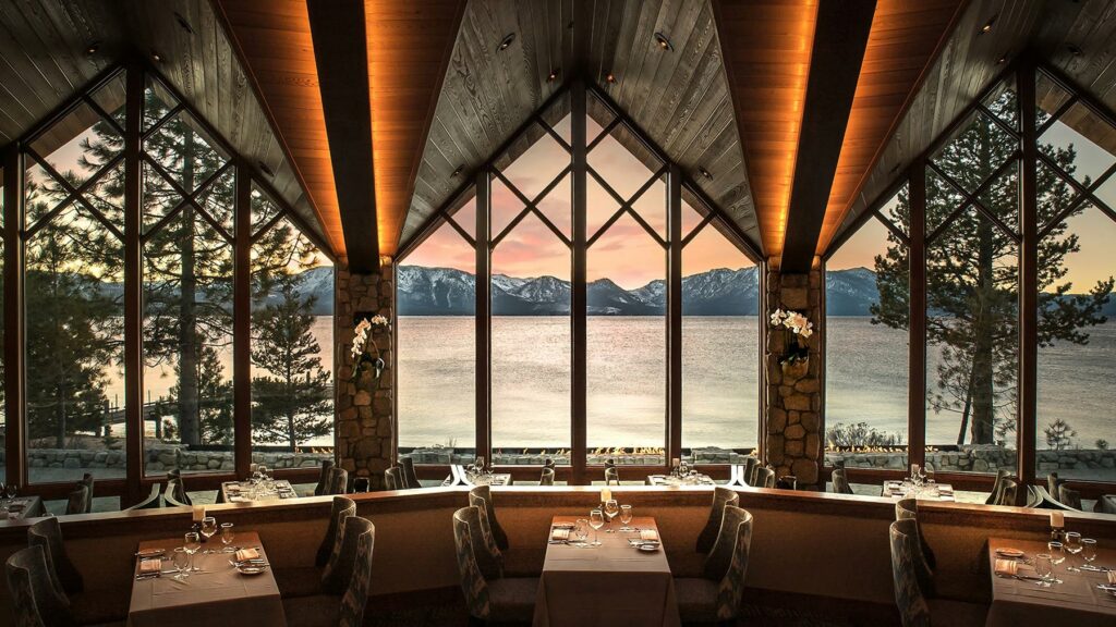 An interior view of Edgewood Restaurant at Edgewood Tahoe Resort with windows overlooking the lake and mountains