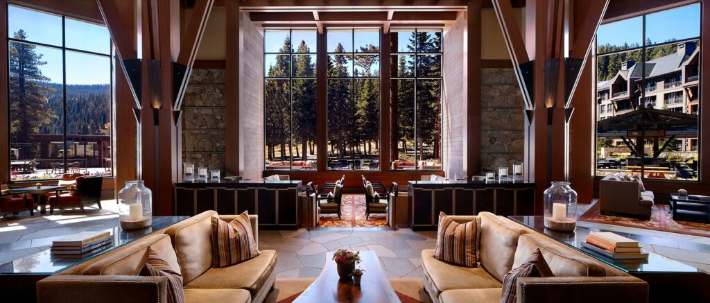A view of the lobby at The Ritz-Carlton, Lake Tahoe with windows overlooking a grove of trees 