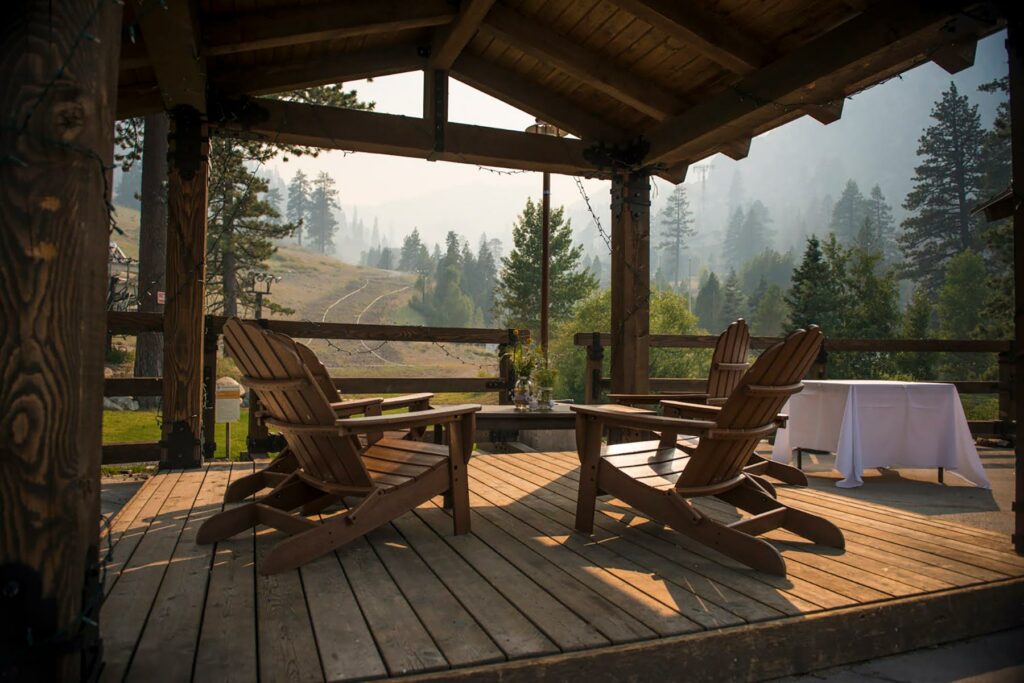A view of a wooden deck overlooking trees and a dirt path at The Village at Palisades Tahoe Hotel