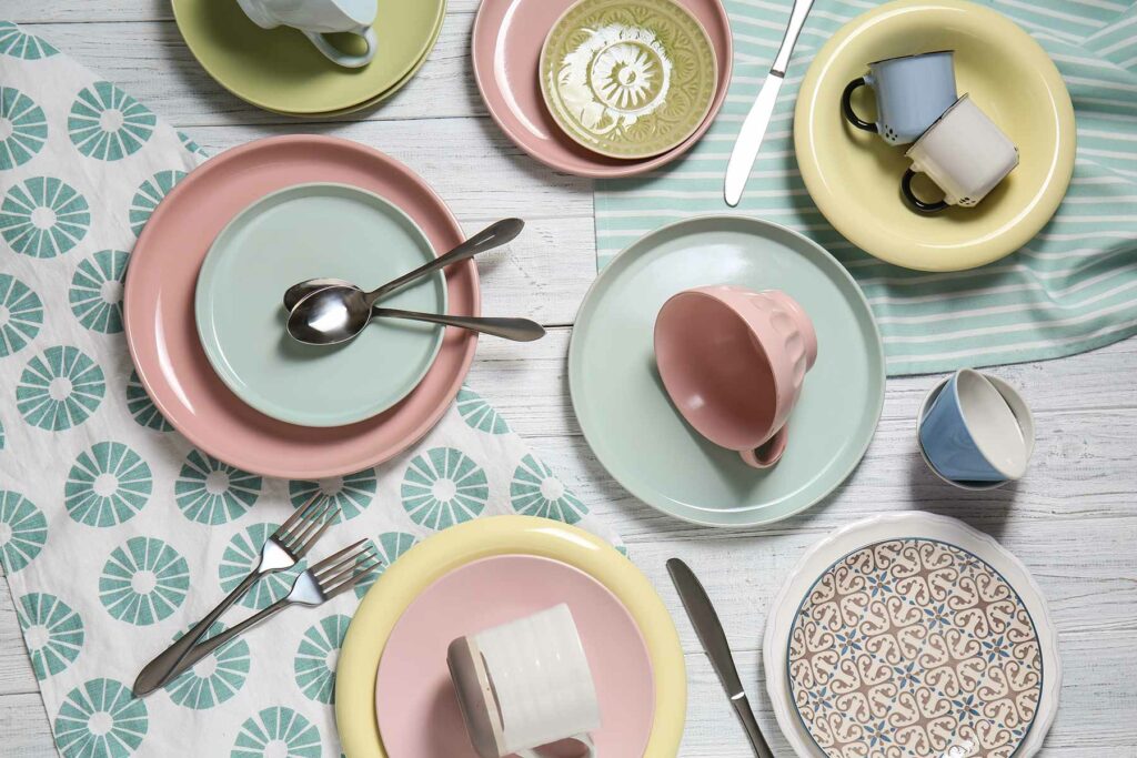 An assortment of pastel-colored dinnerware, including plates, mugs, dessert plates and salad plates