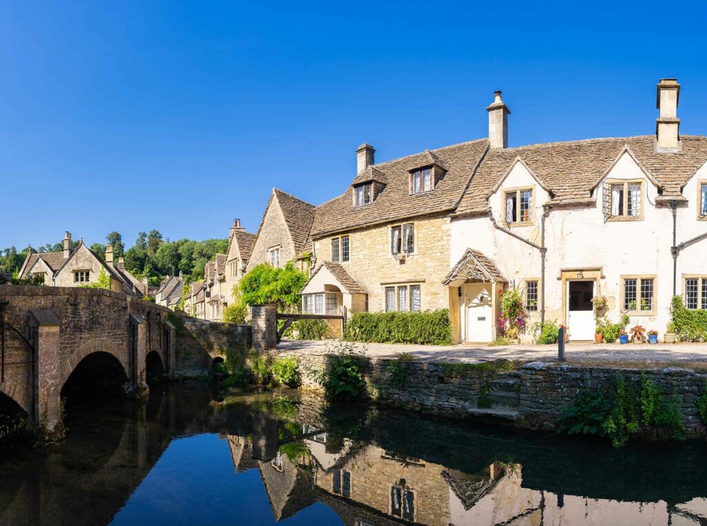 A village in the Cotswolds in England next to the water and a pedestrian bridge