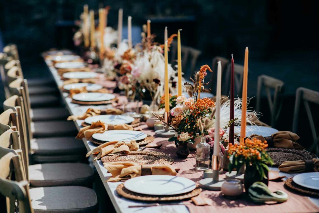 Fall wedding centerpieces with orange taper candles and flowers