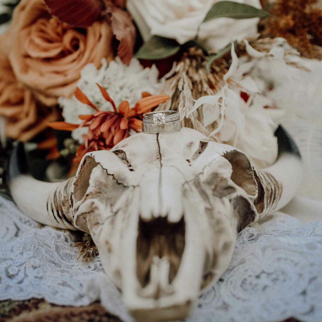 Gorgeous fall flowers positioned next to a skull give off a boho chic vibe