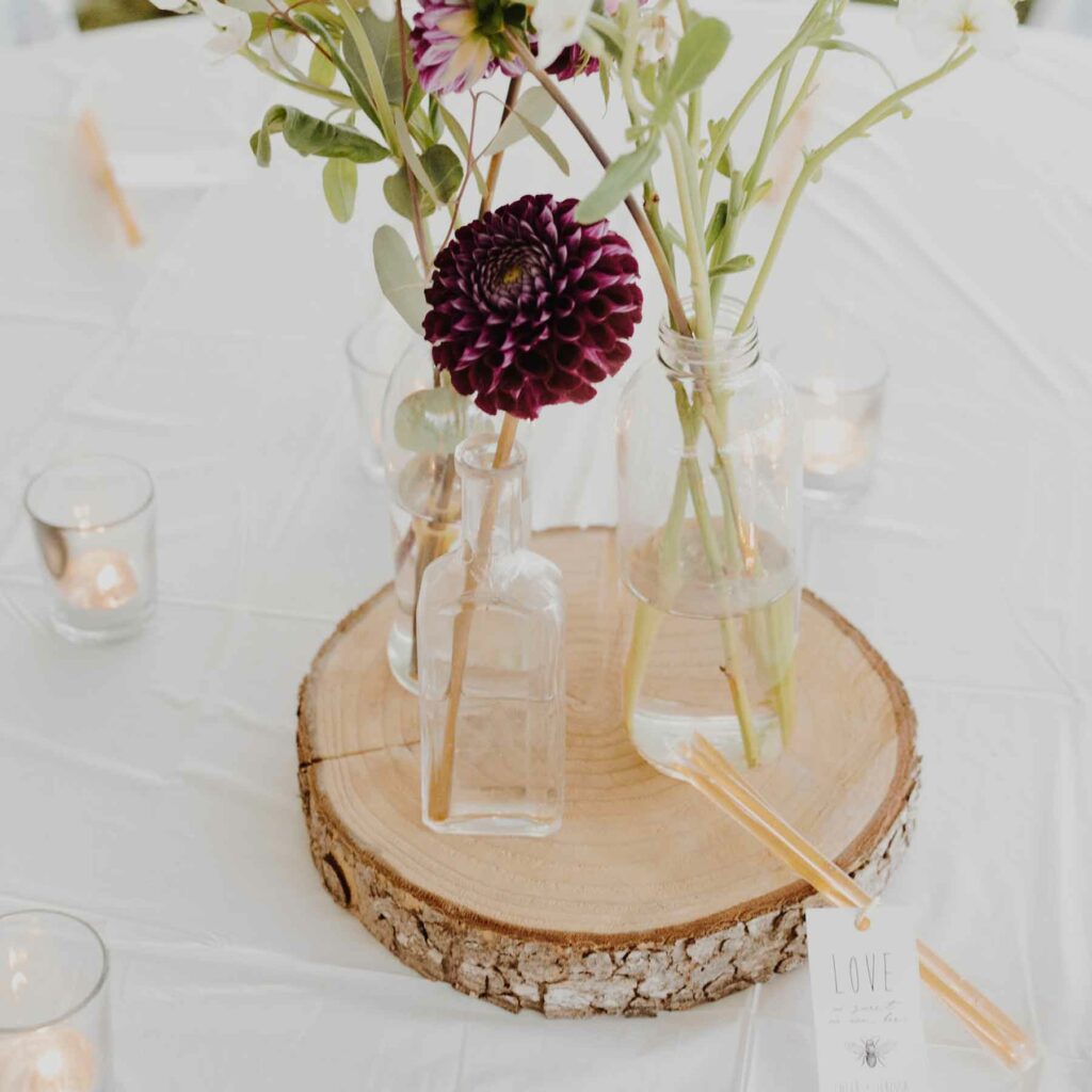 An unfinished tree slice paired with fall flowers at an autumn wedding