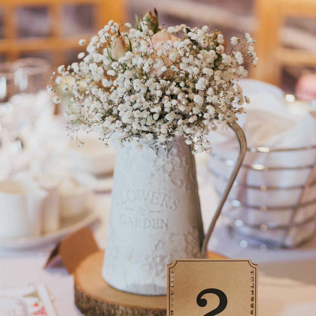 Wedding flowers in an old-fashioned pitcher embody a vintage feel