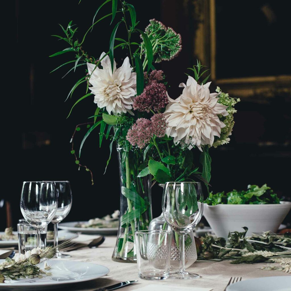 Seasonal dahlias and purple blooms make an elegant floral wedding centerpiece