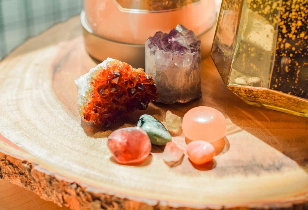 A variety of crystals are positioned on top of a wooden centerpiece at a bohemian-style wedding reception