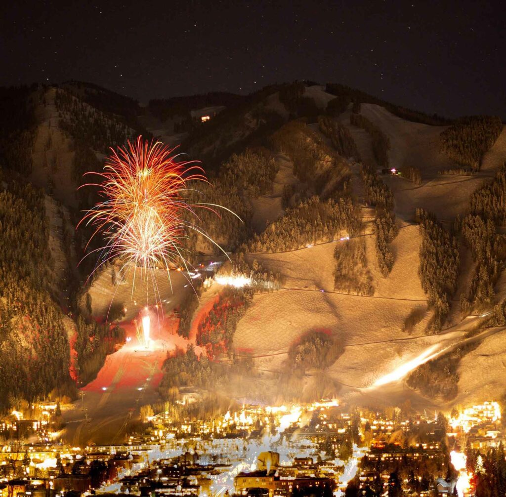 Fireworks illuminate a snow-covered mountain in Aspen
