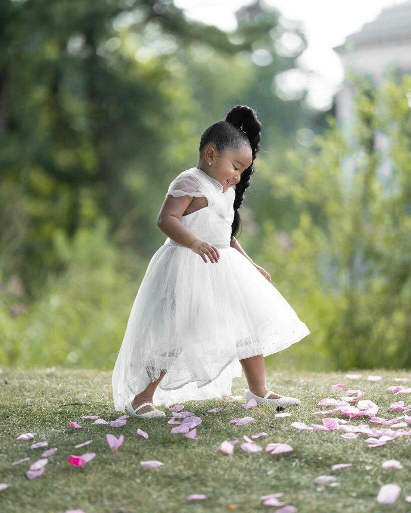 Flower girl in a wedding party walking over petals