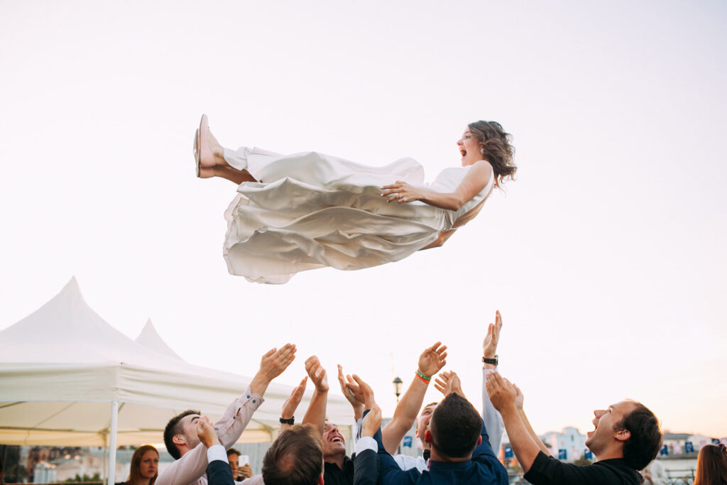Bride being lifted into the air by a wedding party