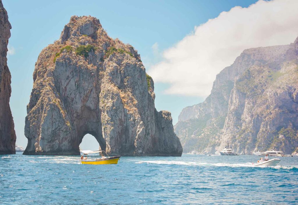 A boat floating near the Arco Naturale in Capri, Italy