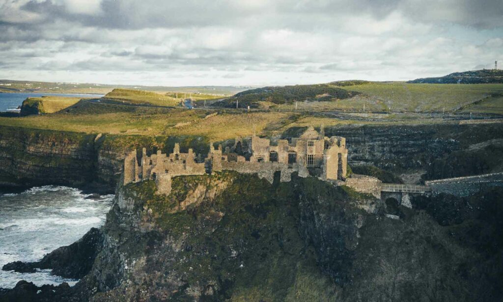 Castle in Ireland atop a green hill next to the water