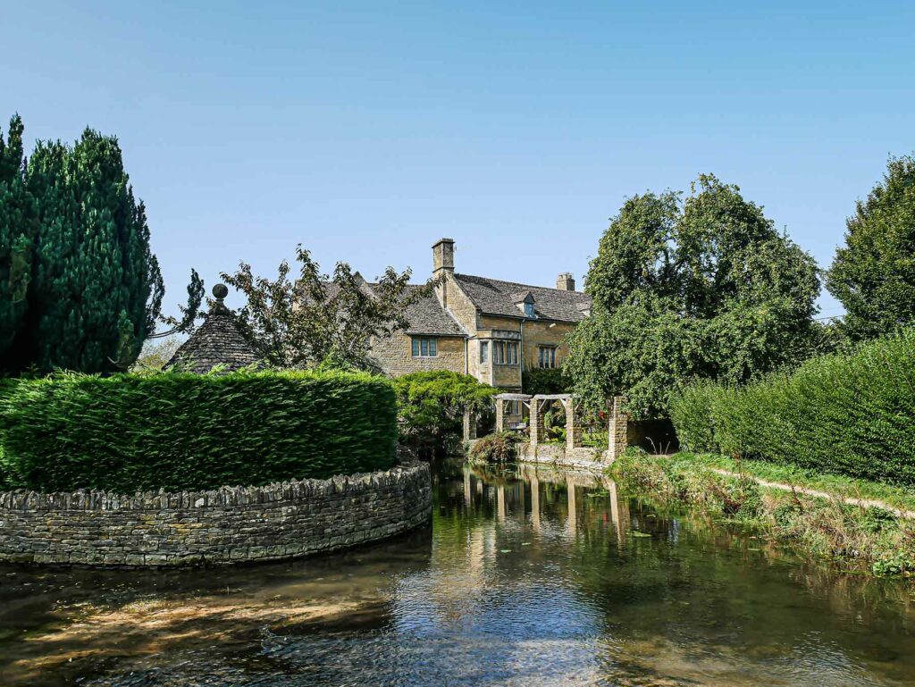 Stone house on the water in a village in The Cotswolds